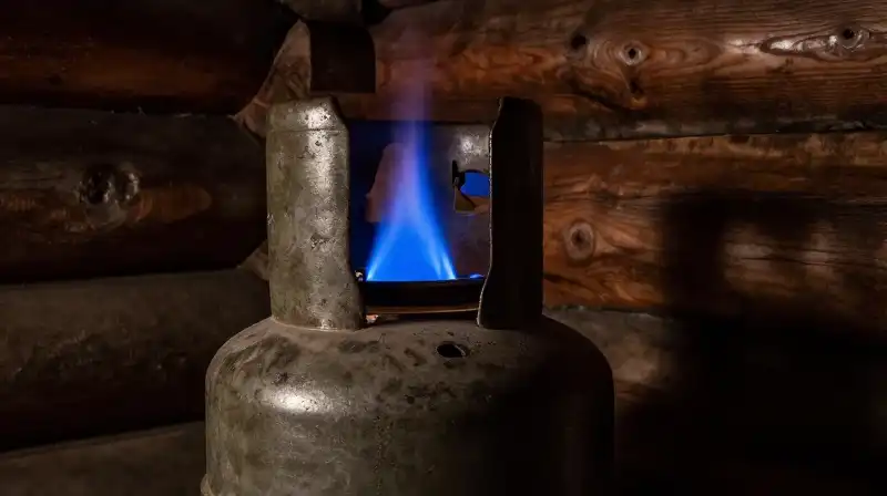 Intense blue fire flickers dramatically inside the rustic log cabin